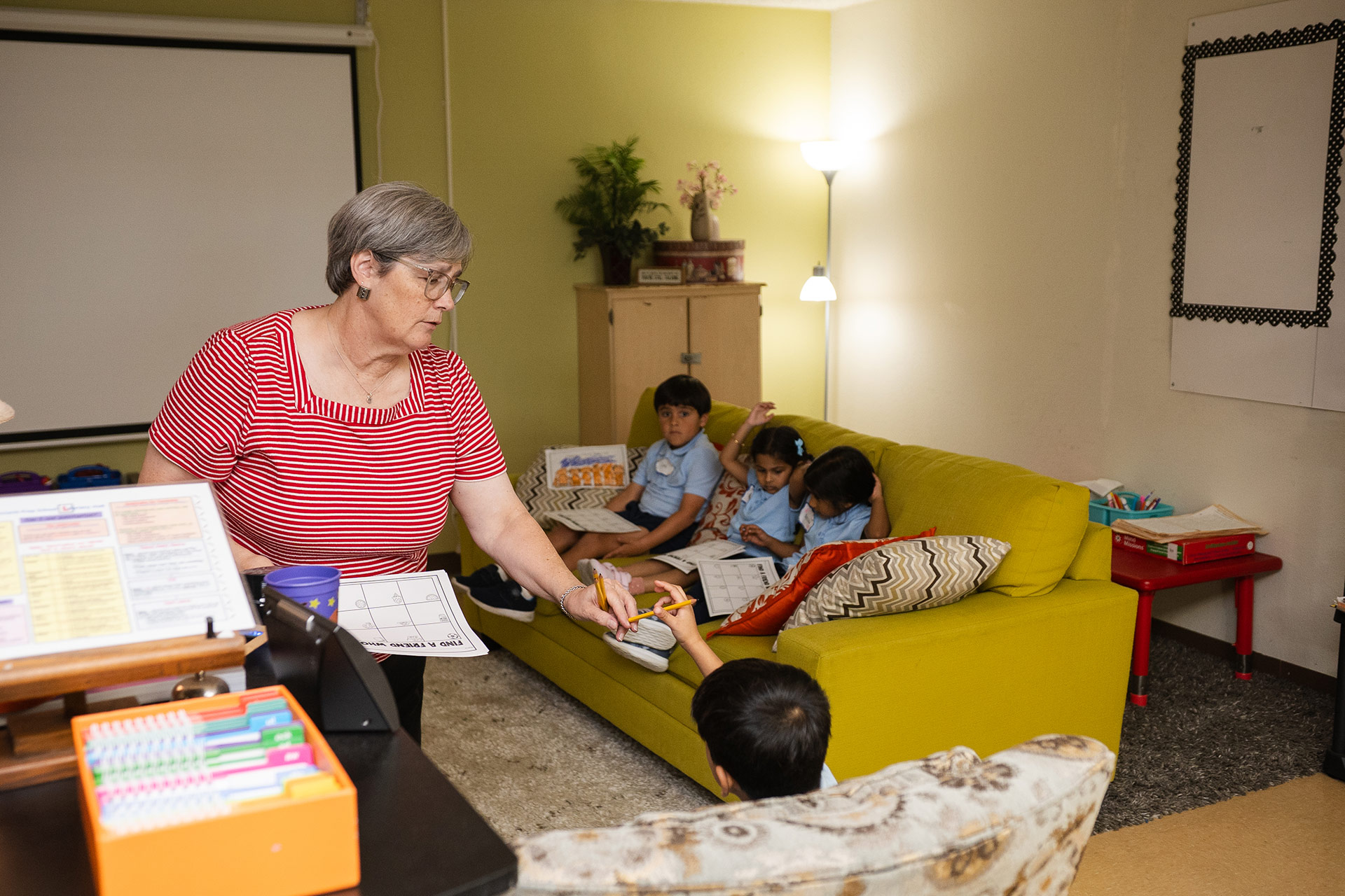 Students learning in classroom environment - Pinnacle Prep School teacher assisting PreK-8th students in a nurturing classroom setting